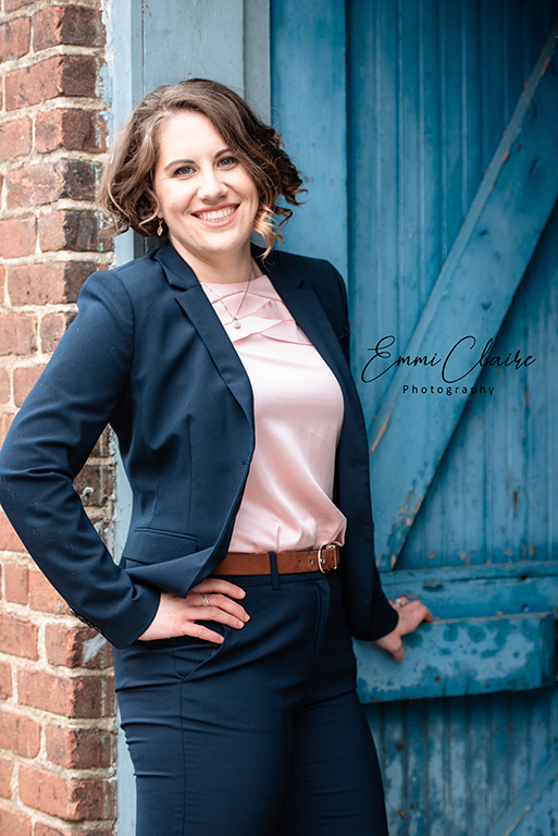 A headshot of a woman in a navy blue blazer and matching pants with a silk pink shirt taken as a part of her branding photography package