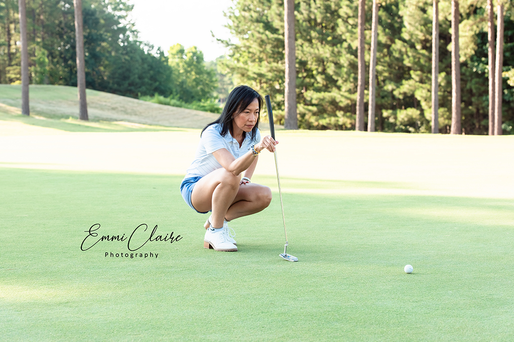 A female golfer watches her put in Southern Marsh gear.