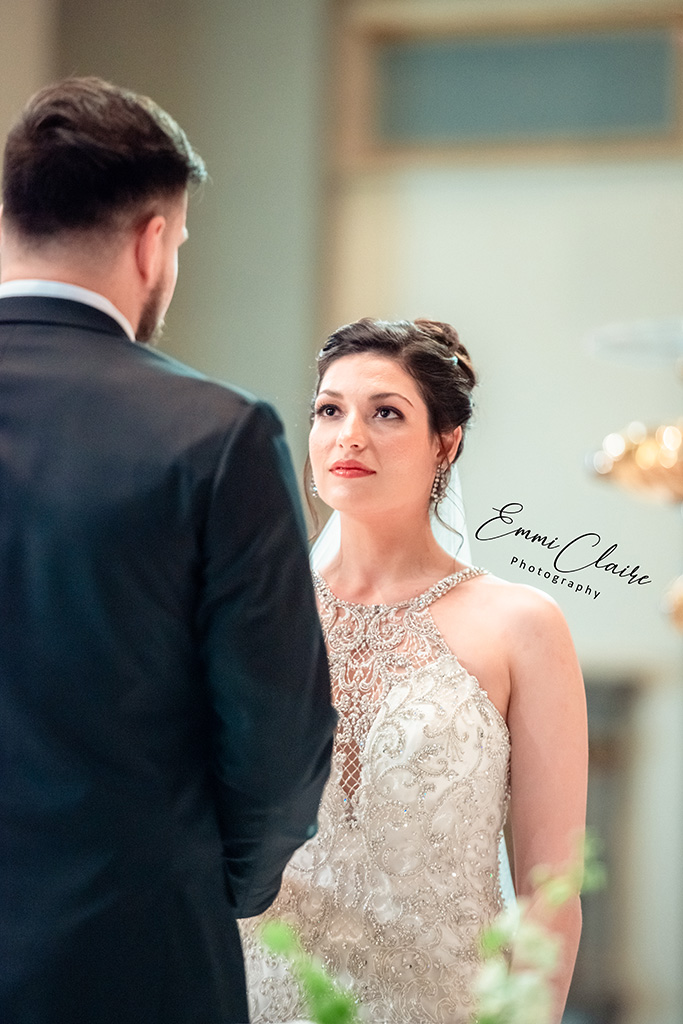 bride looking lovingly into her grooms eyes as they stand together at the altar before they say I do