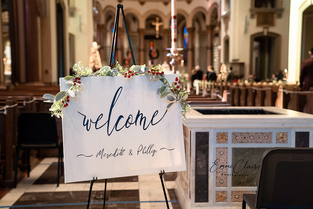 welcome sign that reads "welcome Meredith and Phillip" stationed so guests can see it as they arrive to their cathedral wedding