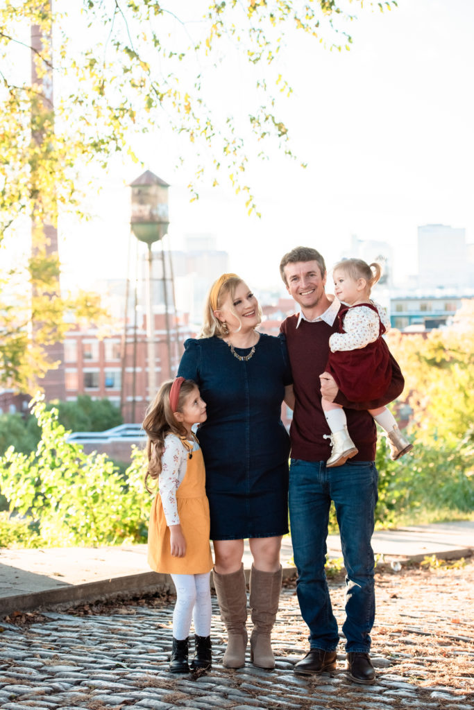 family of four smiles and poses together at Libby Hill during their family photoshoot  