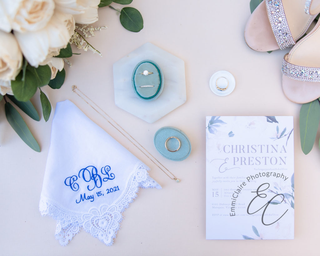 A flatlay of wedding details such as rings, shoes flowers, and a handkerchief as an example of great wedding detail photography 