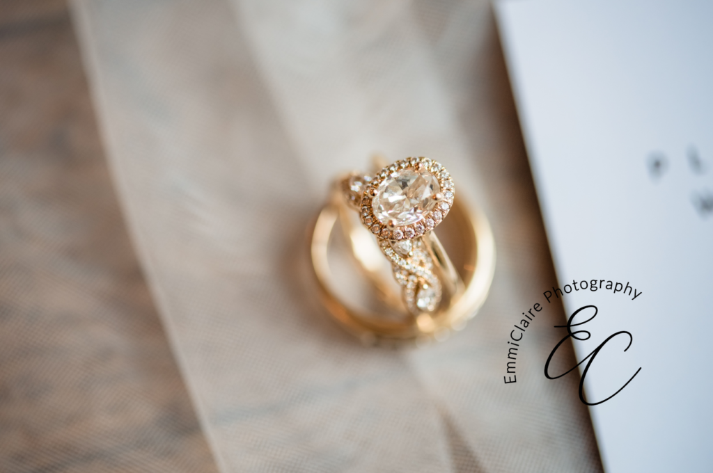 macro shot of the bride's engagement ring and wedding band showing off the fine diamond and gold details of her jewelry