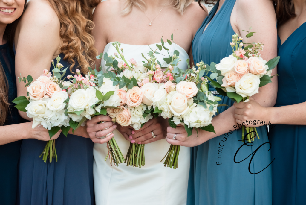 detail shot of the bride and her bridesmaids in their blue dresses holding their bouquets together