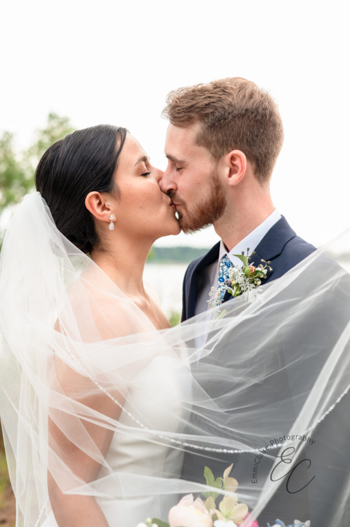 bride and groom share a romantic kiss following their wedding ceremony during their intimate coastal cottage wedding