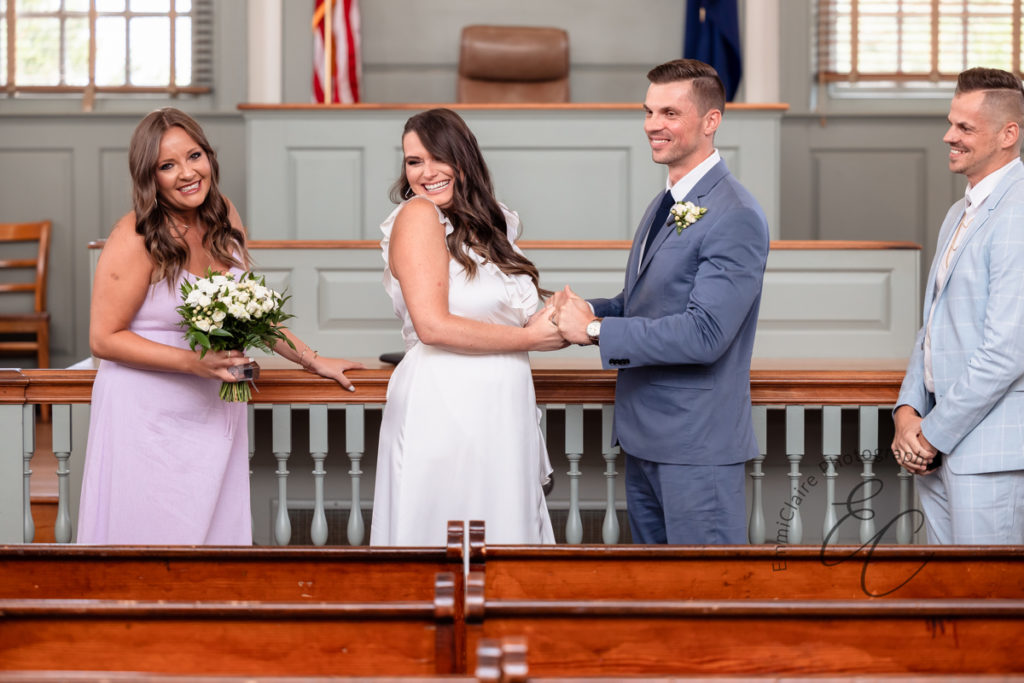 Couple smiles during their intimate courthouse wedding ceremony as they prepare to make their union official