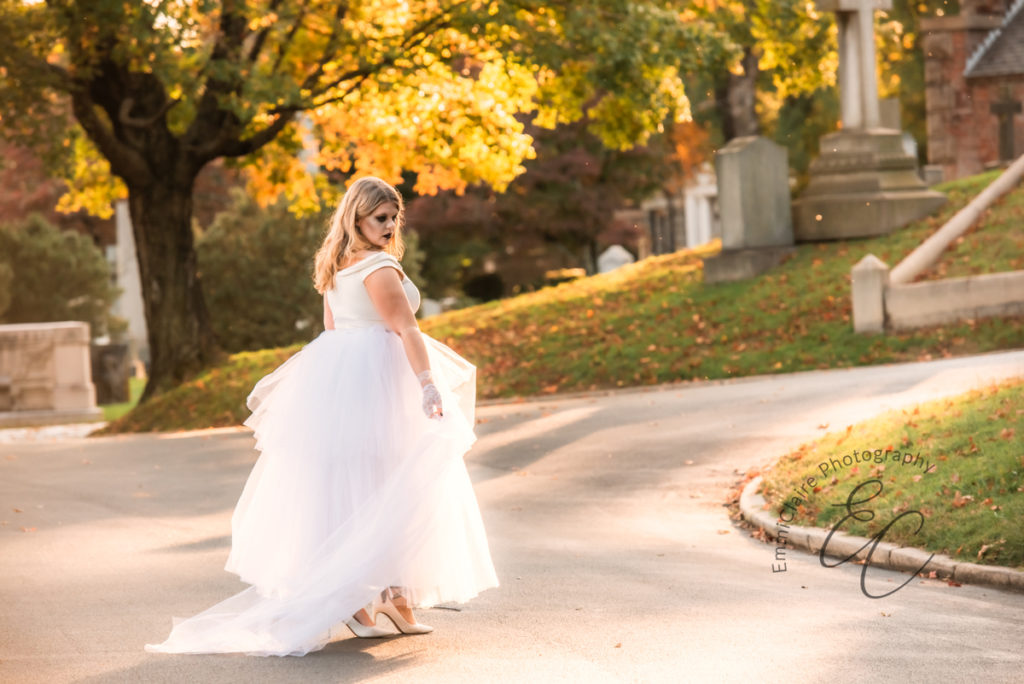 ghost bride walking towards the cemetery in her wedding dress during a wedding photoshoot inspired by Halloween