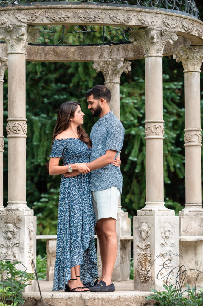 couple locks eyes under a beautiful marble gazebo as they celebrate their engagement with a photoshoot session