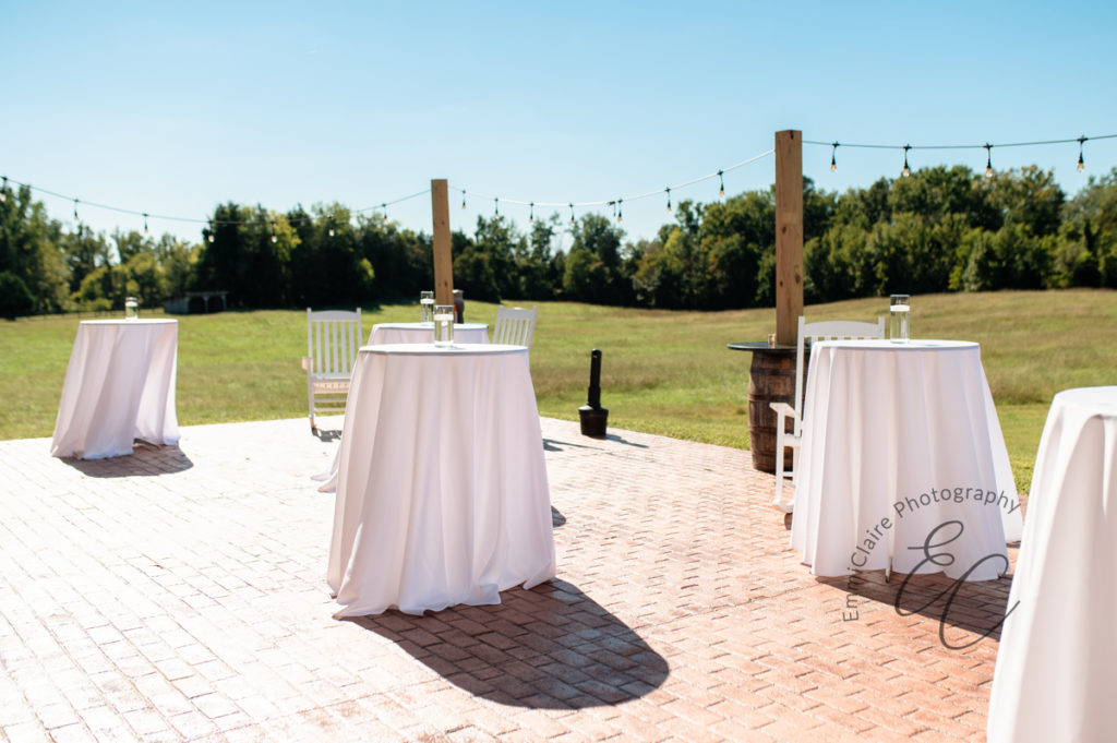 Outdoor tables as a part of the reception photographed midday while the guests have yet to arrive on a sunny day