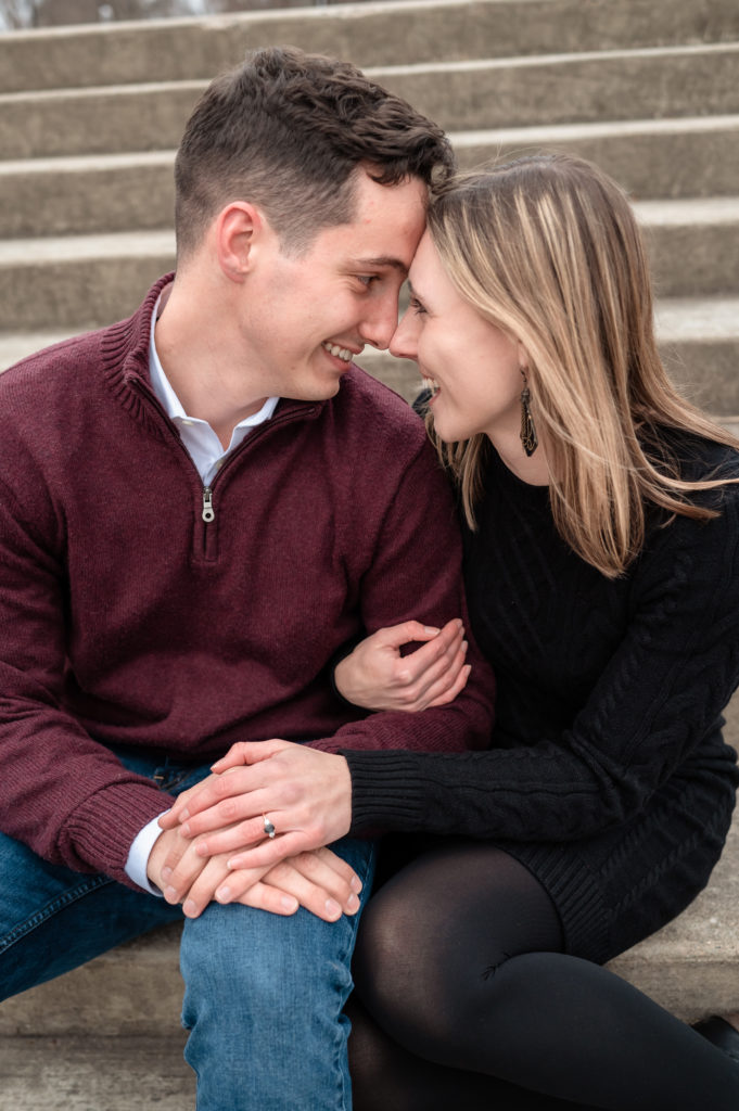 A close up of the smiling couple gazing at one another with foreheads pressed together as they sit on stairs at Libby Hill Park in RVA.