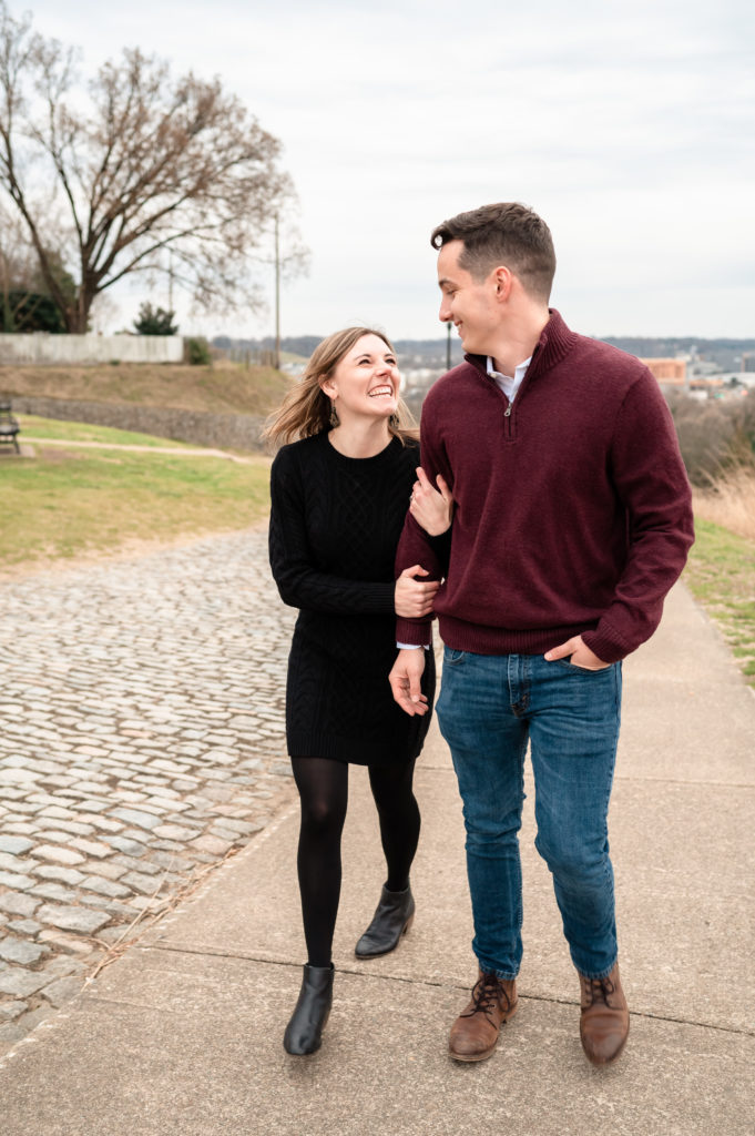 Caroline smiles up at Justin as the two walk along a path at Libby Hill Park in Richmond, Virginia.