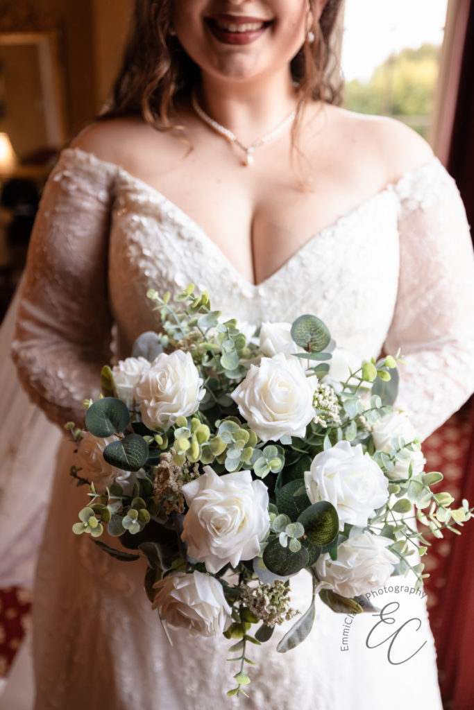 A close up shot of the bride's bouquet - white roses with a variety of soft green eucalyptus.