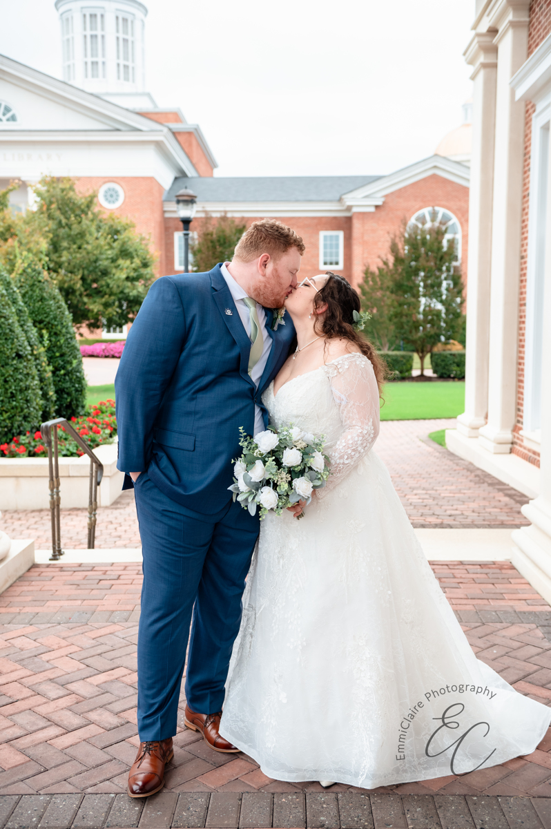 The bride and groom kiss on campus at CNU.