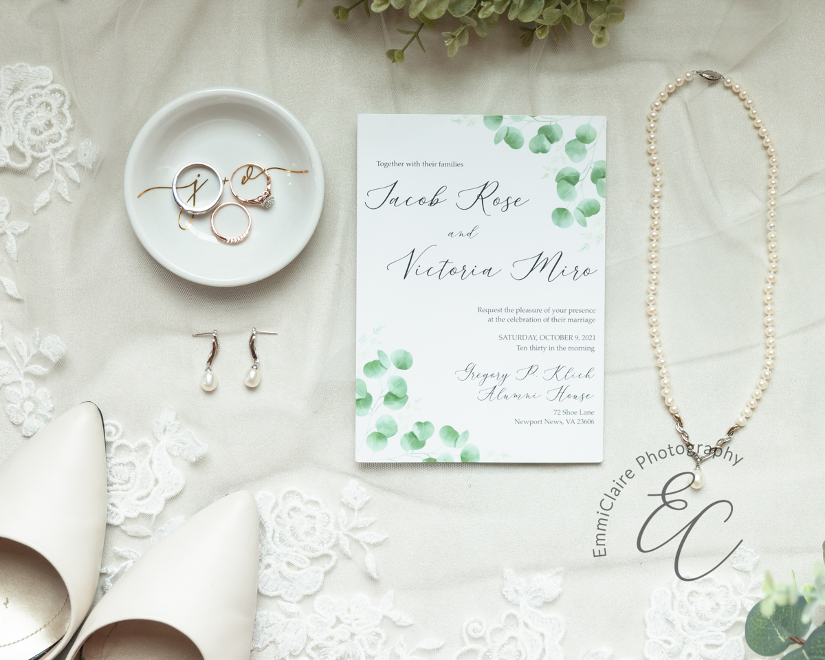 A flat lay of the wedding invitation and bridal accessories.