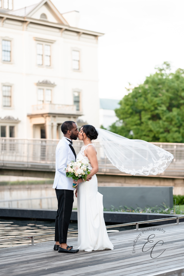 Rakeshia and Gregory kiss on their wedding day in front of canal.