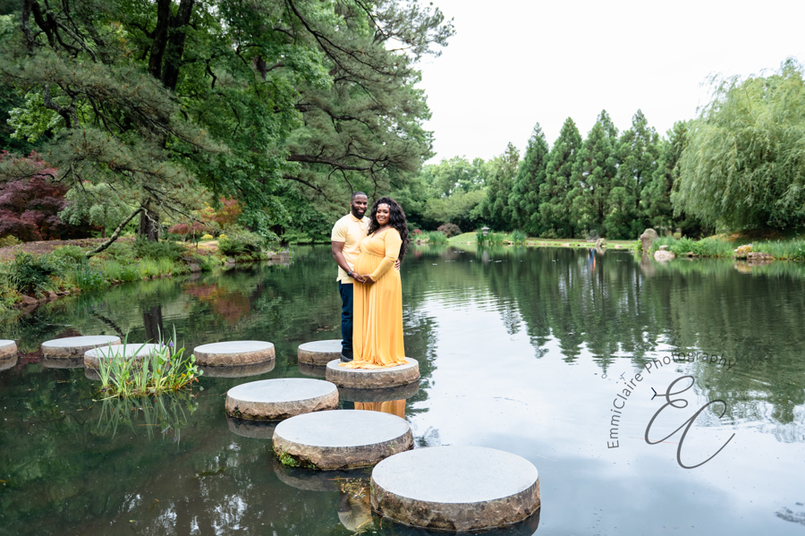 Shana and Chris stand together on a stepping stone in the middle of a pond at Maymont Park.