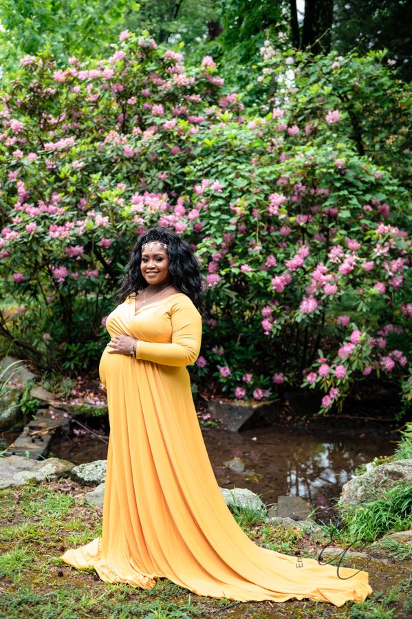 Shana smiles for the camera as her hand rests lovingly atop her pregnant belly during her maternity session at Maymont Park in RVA.
