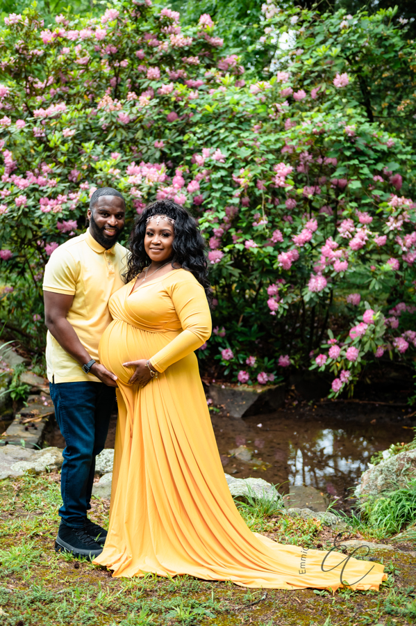 Shana and Chris stand in front of a beautiful azalea bush at Maymont Park during their maternity session in Richmond, VA.