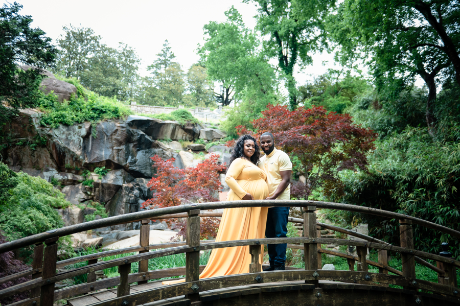 Shana and Chris stand on the Japanese Bridge at Maymont Park, a waterfall in the background.