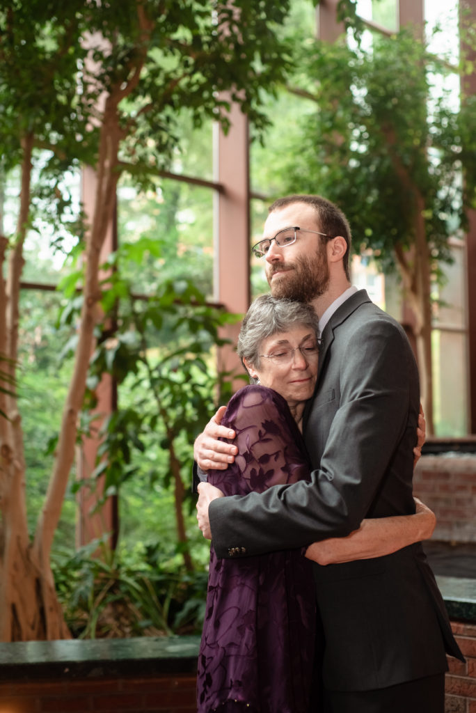 The groom hugs his mother before his atrium wedding ceremony in Charlottesville, VA