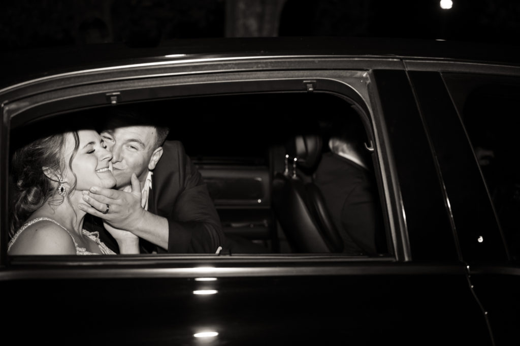 Groom kissing bride in getaway car