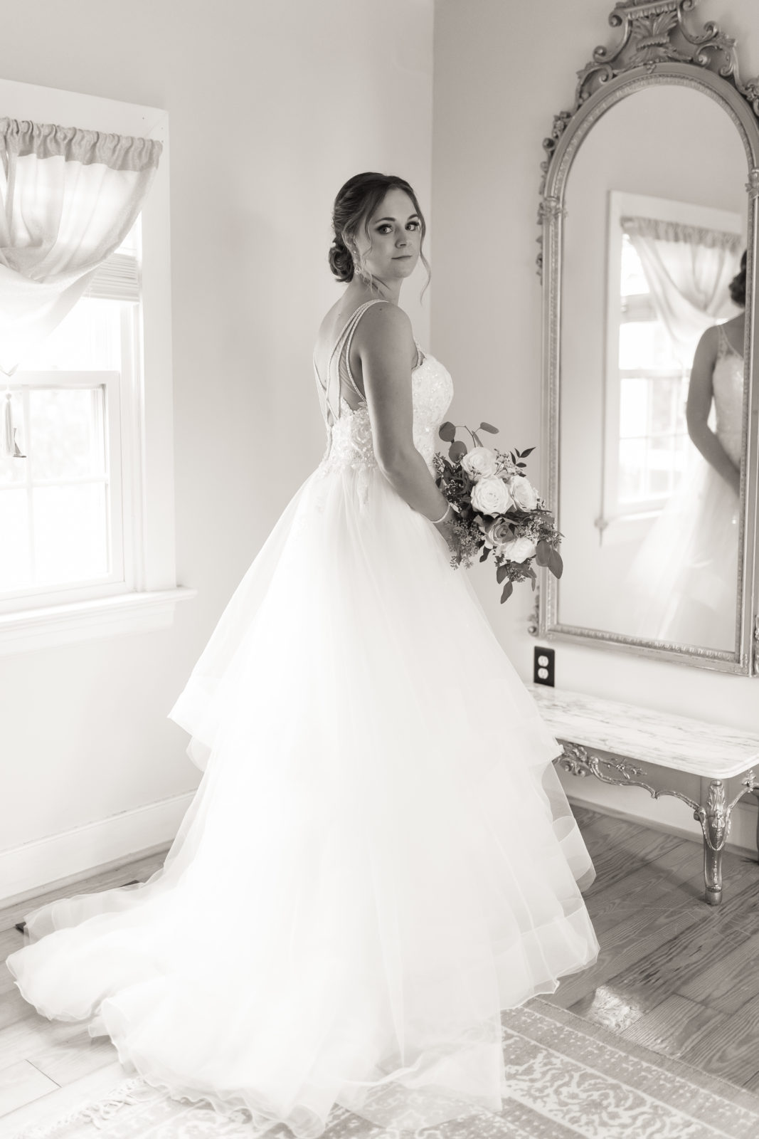 Bride looking in mirror at her dress