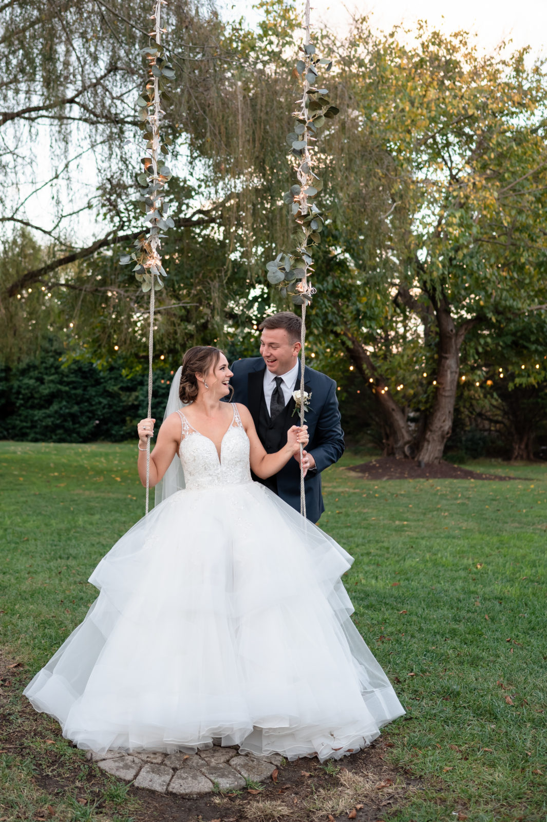 Bride and Groom photo with groom pushing bride on swing
