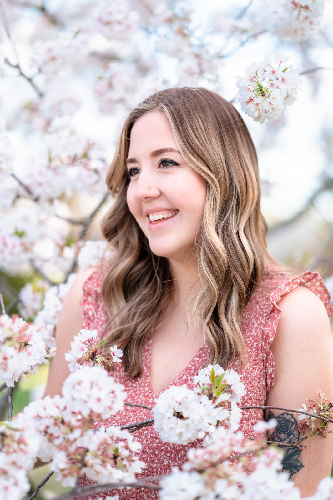 headshot of woman in between cherry blossom tree