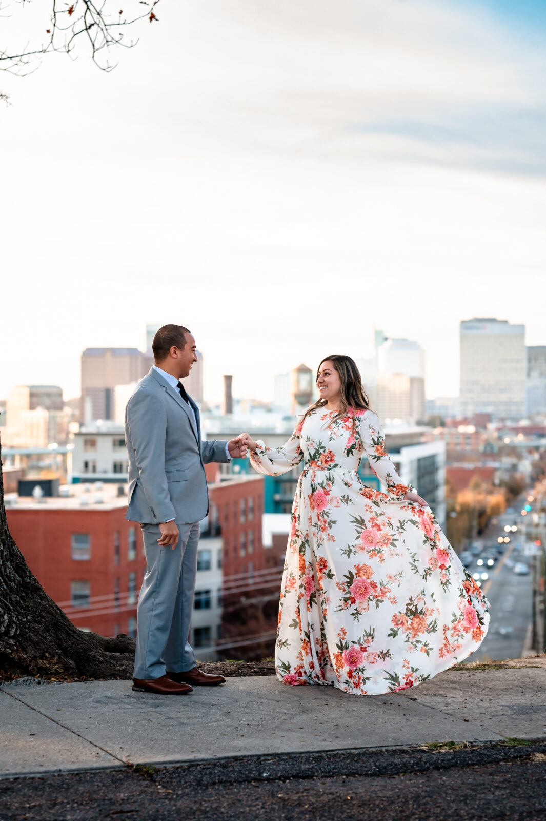 A couple embracing at Libby Hill Park with the Richmond skyline in the background