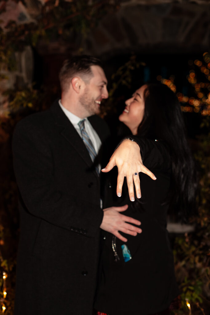 Terri and Kevin smiling together after their engagement at Lewis Ginter GardenFest of Lights, captured by EmmiClaire Photography.