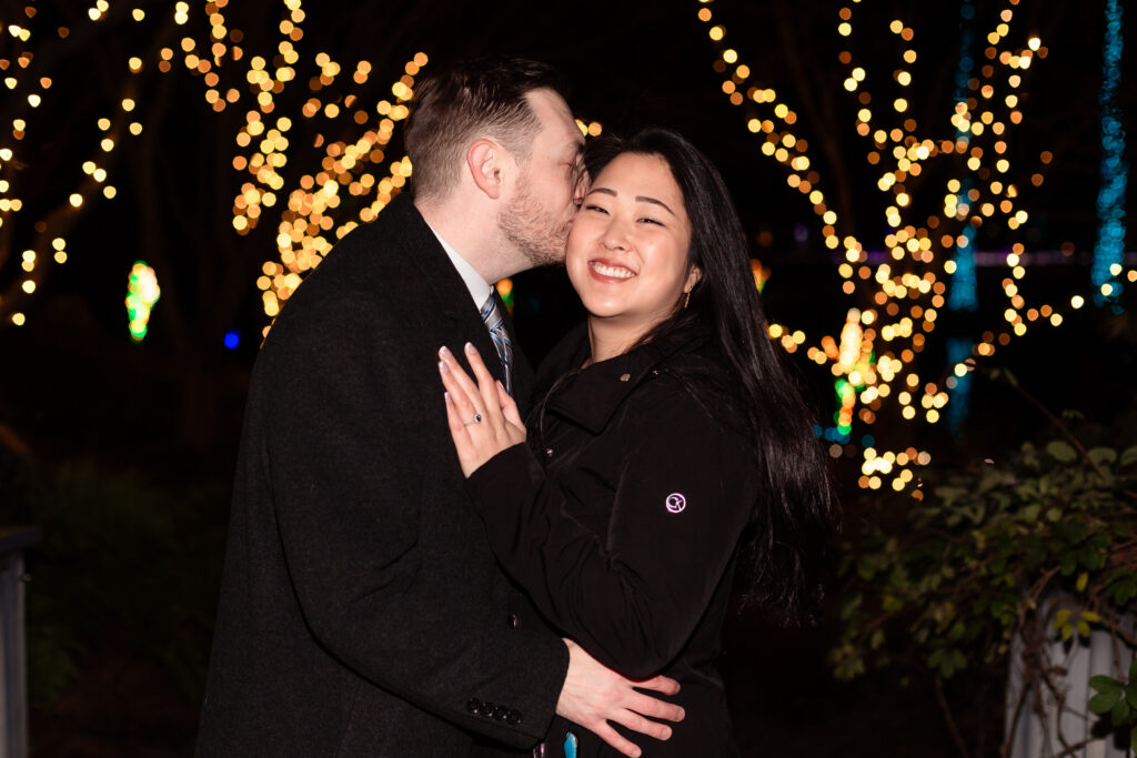 Terri and Kevin smiling together after their engagement at Lewis Ginter GardenFest of Lights, captured by EmmiClaire Photography.