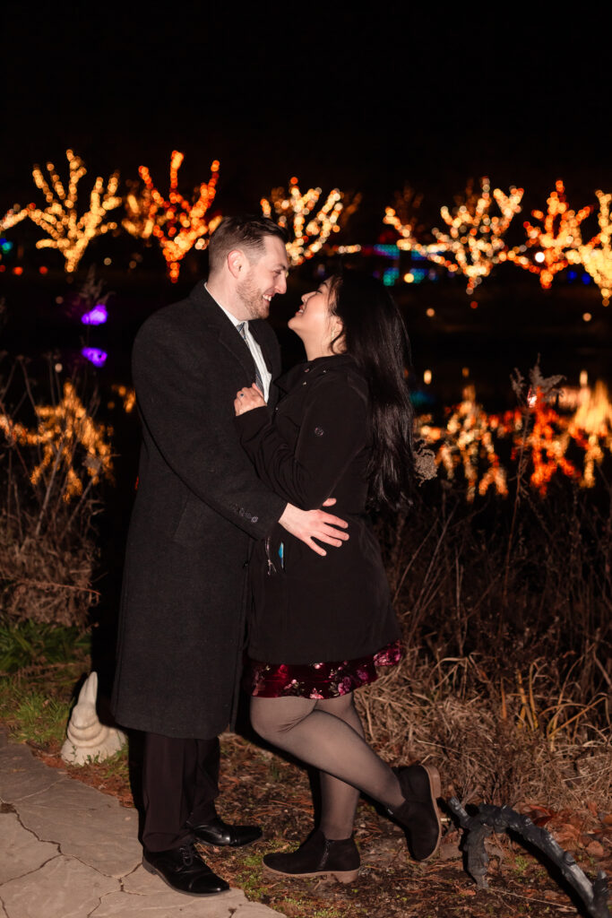 Terri and Kevin smiling together after their engagement at Lewis Ginter GardenFest of Lights, captured by EmmiClaire Photography.