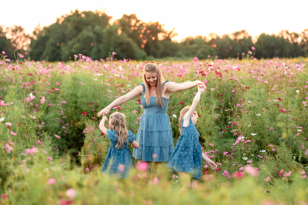 mother and daughters twirling during wildflower photo session in northeast florida