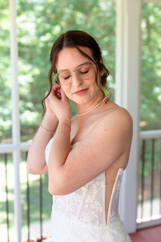 bride putting on heirloom pearl necklace before montfair resort farm wedding