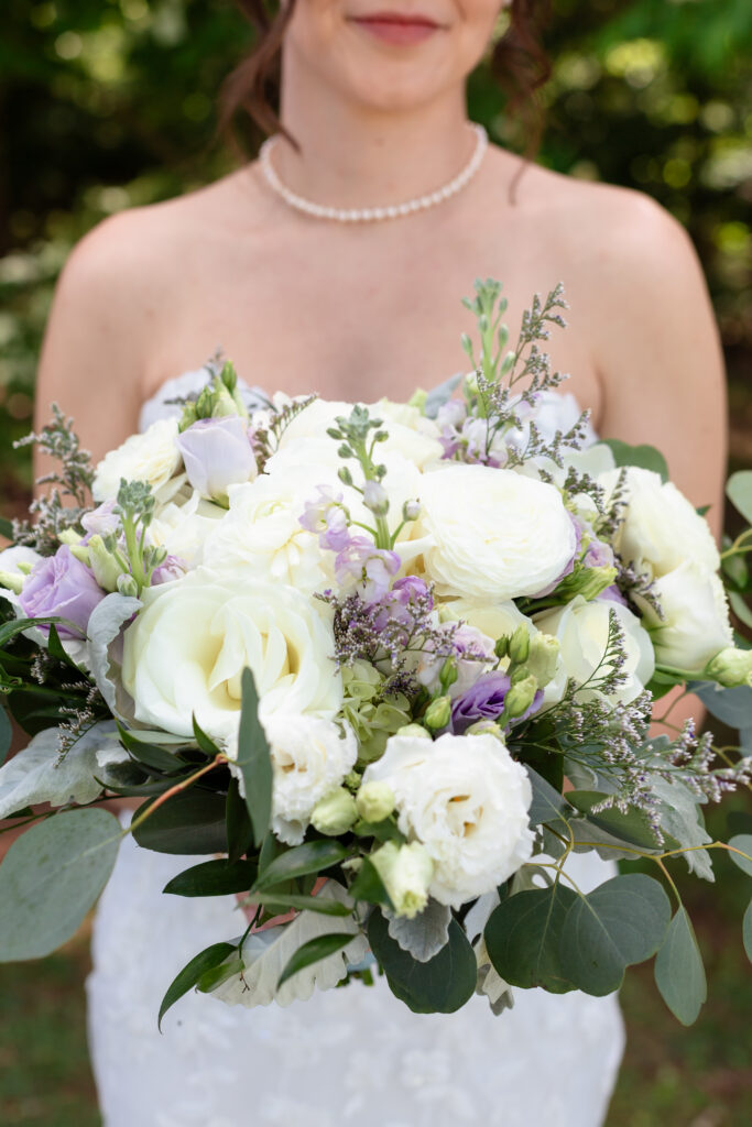 Bride holding her flower arrangement of lavendar and sage.