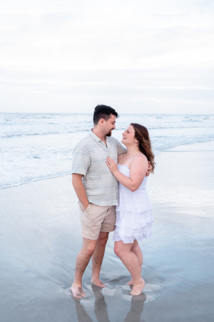 Couple embracing on the sand at sunset near One Ocean Resort & Spa