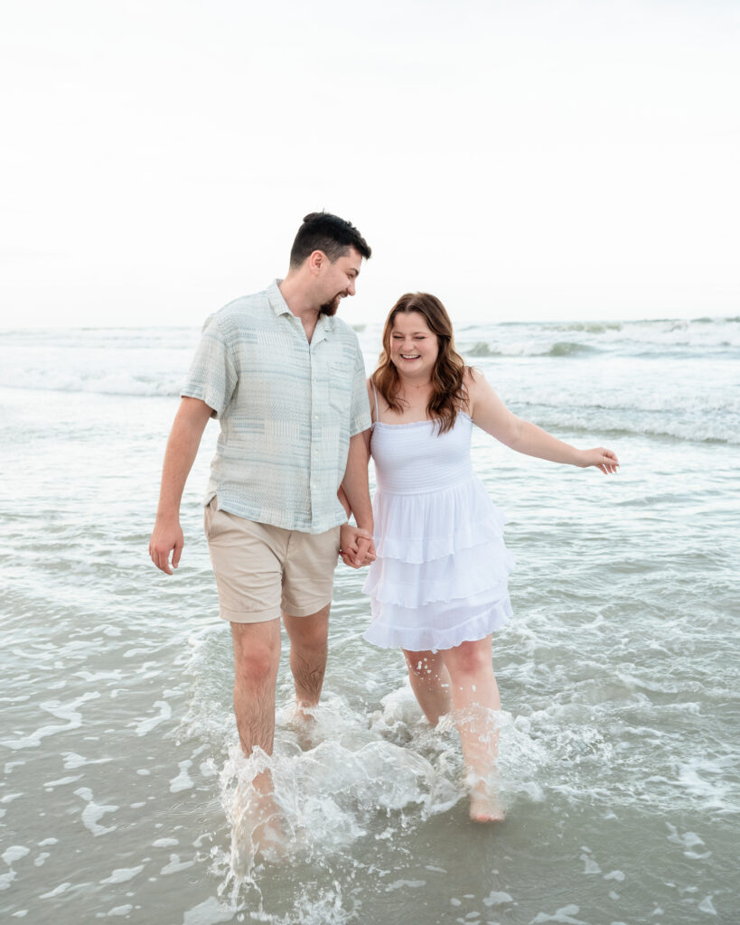 Jack and Emily smiling and holding hands after their Jacksonville Beach proposal