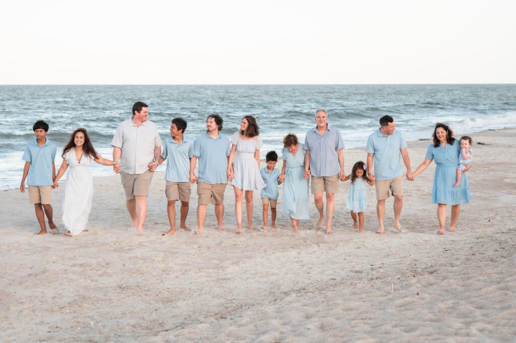 The Denning family gathered in a wide group photo with the Atlantic Ocean waves glowing behind them.