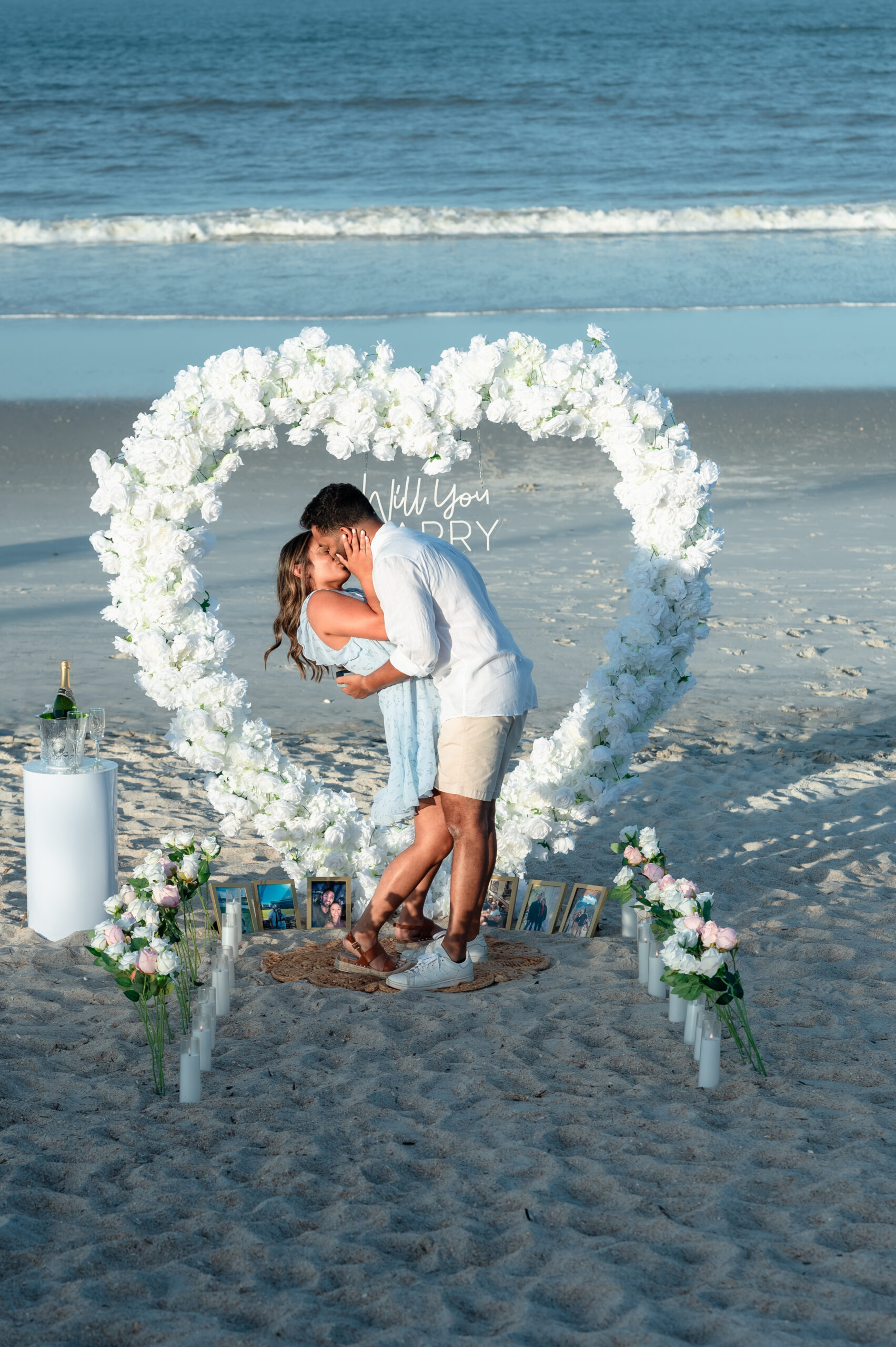 Sahil kneeling during Ponte Vedra Beach proposal photography with floral arch backdrop