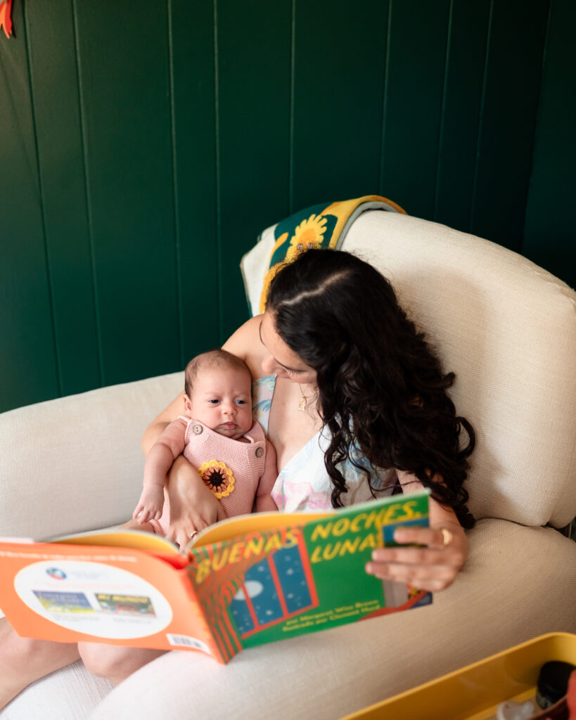 detail of nursery with parents holding newborn in rocking chair