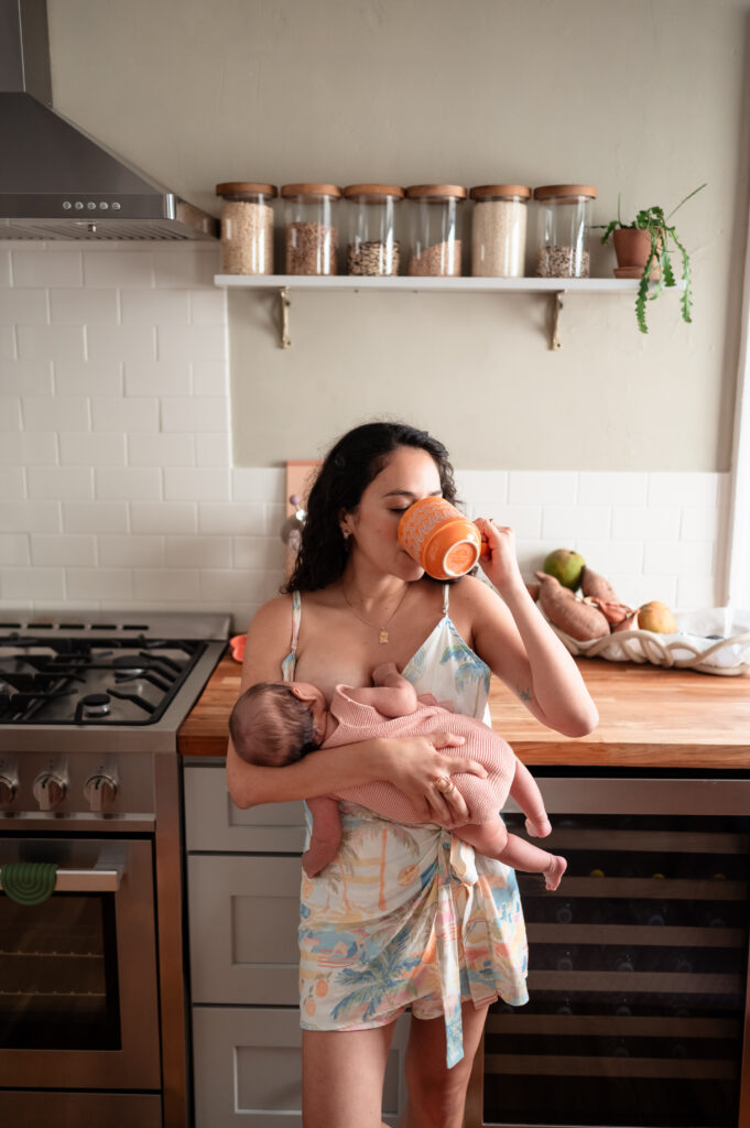 newborn sleeping in mom’s arms during lifestyle session at home