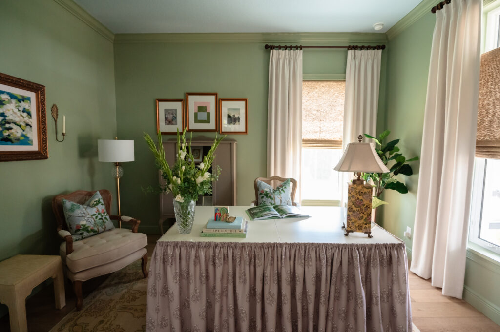 Home office with sage green walls and natural light during branding photography session.