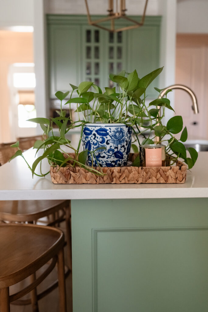 Kitchen branding photo with mint-green cabinets and brass light fixtures.