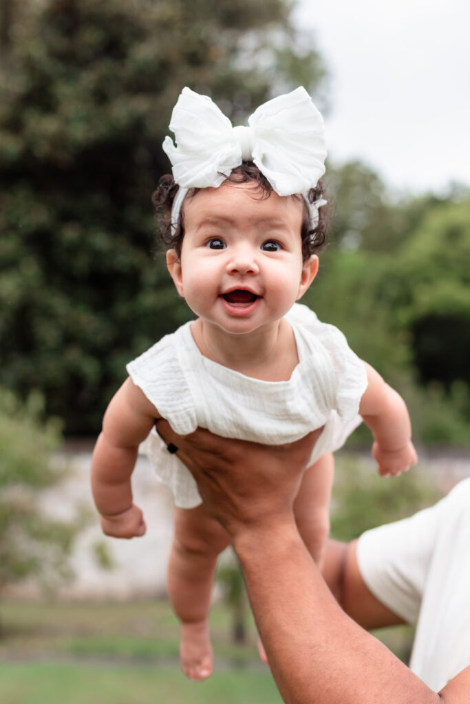 Baby girl looking at camera during garden portraits