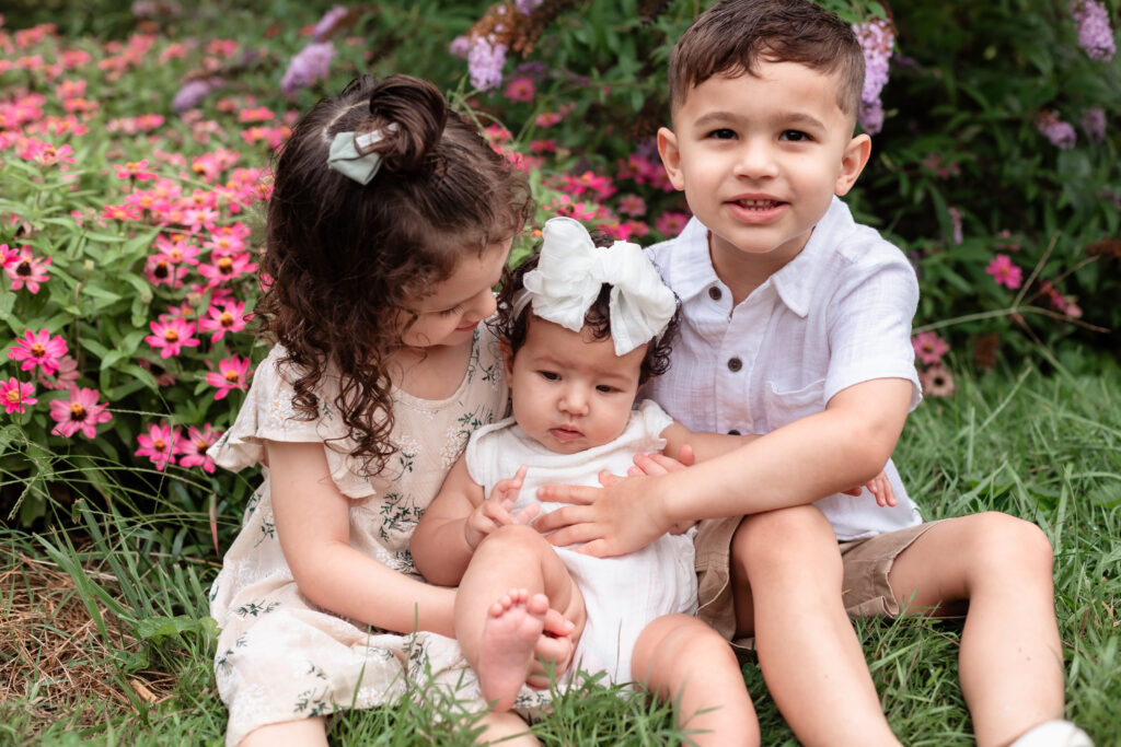 Baby girl sitting with siblings during family photos
