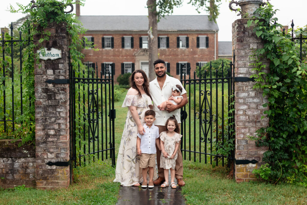 Family portrait in front of historic brick manor house