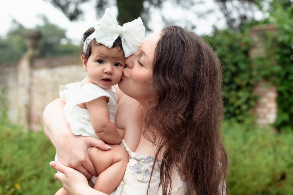 Mom holding baby daughter in outdoor family session