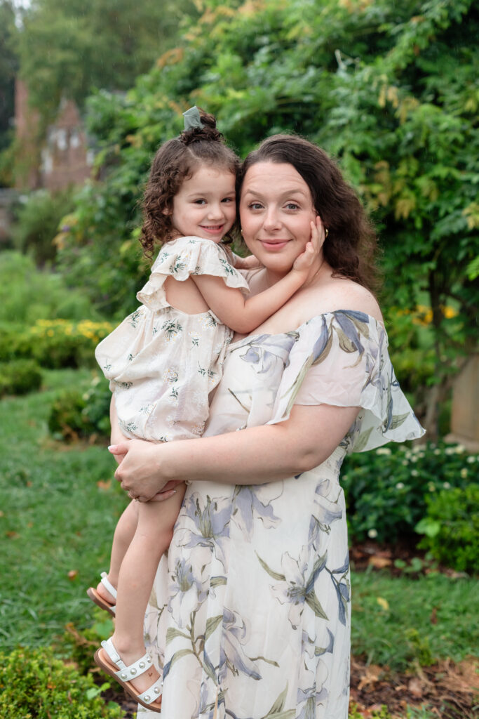 Mom holding daughter’s hand in Chatham Manor gardens