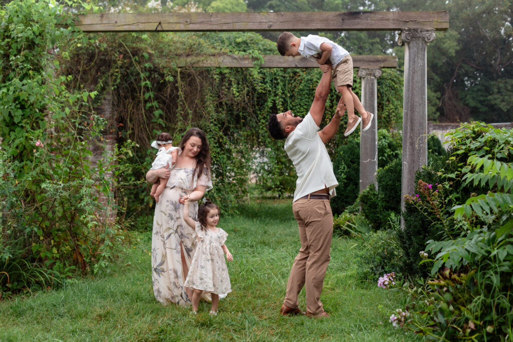 Dad lifting son in garden during Fredericksburg family photos