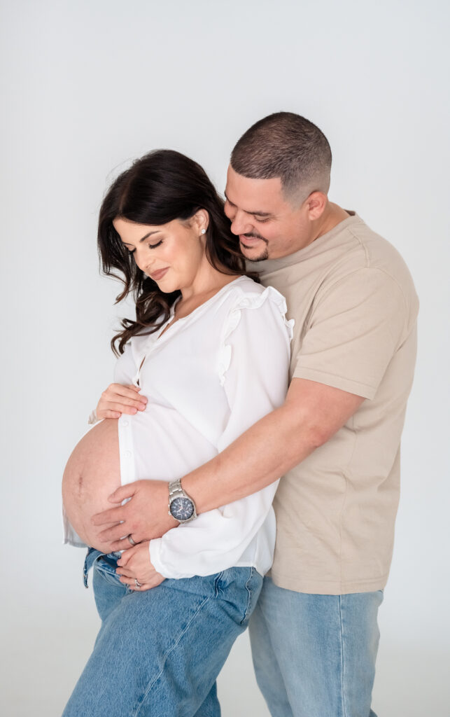 Couple posing during studio maternity session at Jax Mini Sessions Studio.